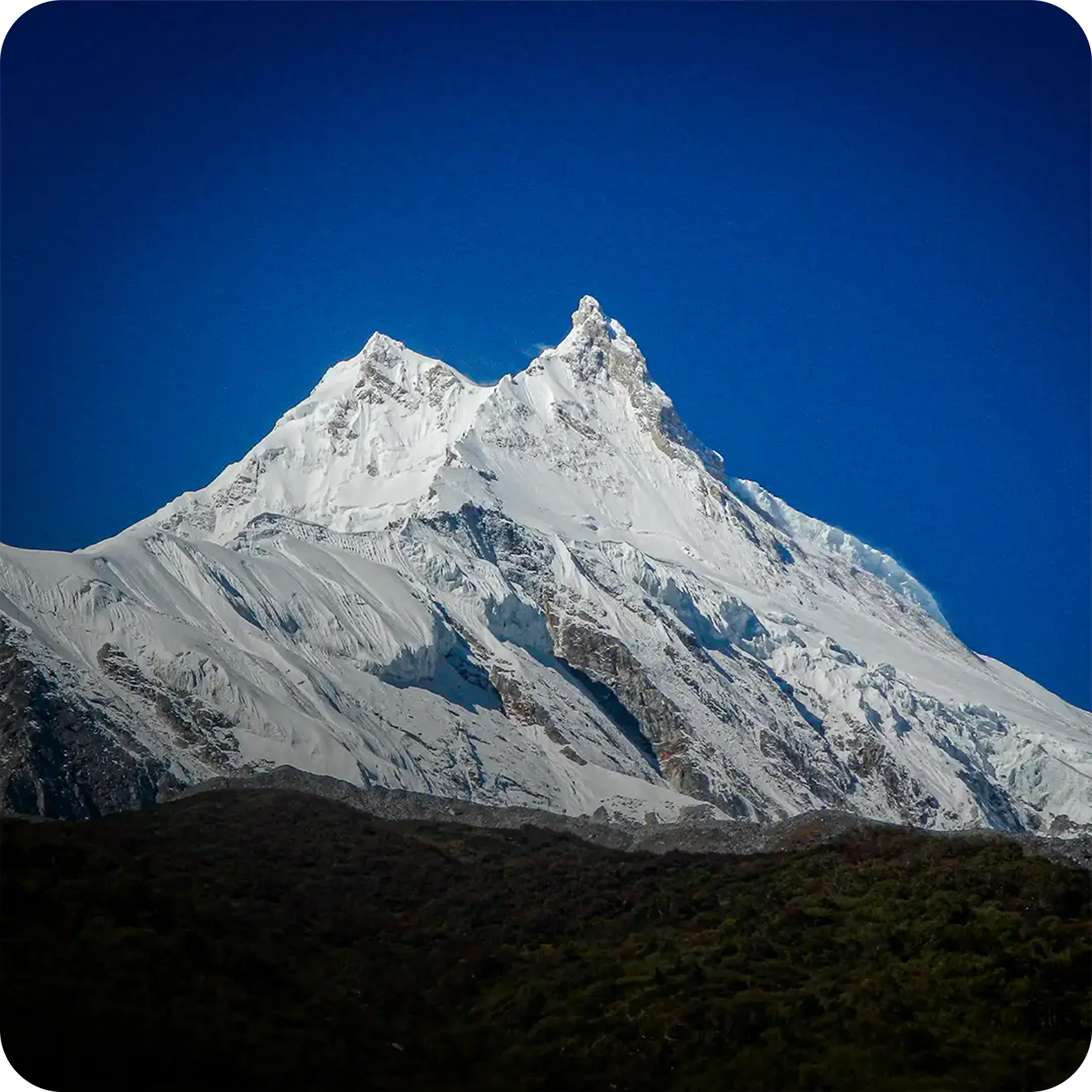 Snow-capped Annapurna peak above blue sky